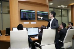 Des traders travaillent dans une salle des marchés d'une société de valeurs mobilières. Photo: VNA