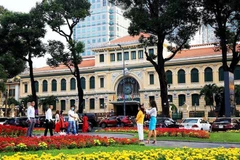 Des touristes devant la Poste centrale de Hô Chi Minh-Ville. Photo: VNA