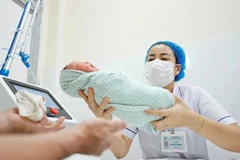 Le personnel médical prend soin d'un nouveau-né. Photo : VNA