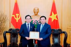 Le membre du Politburo, président de l’Académie nationale de politique Hô Chi Minh (HCMA) et président du Conseil théorique central, Nguyên Xuân Thang (à droite) décerne l'Insigne de l'HCMA «Pour la cause de l'éducation et de la formation en théorie politique» au directeur général de Samsung Vietnam, Choi Joo Ho. Photo : VNA