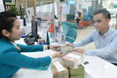 Un client dépose son épargne à une banque à Hanoi. Photo: vneconomy.vn