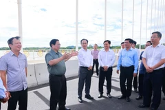 Le Premier ministre Pham Minh Chinh (2e à partir de la gauche) sur le pont Nguyên Hoàng sur la rivière Huong, à Huê. Photo : VNA