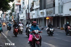Des habitants, vêtus chaudement, se déplacent dans la rue Hô Van Huê, dans le quartier de Duc Nhuân, à 6h20 le 9 janvier, pour se rendre au travail. Photo : VNA