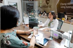 Une cliente effectue un dépôt dans un guichet bancaire à Hanoi. Photo : VNA