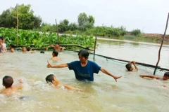 Trân Thi Kim Thia enseigne à nager des enfants dans la région de Dông Thap, dans le delta du Mékong. Photo: congthuong.vn