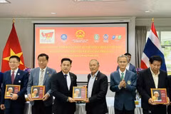 Des ressortissants vietnamiens reçoivent une copie du livre bilingue "L'Oncle Hô en Thaïland". Photo: VNA
