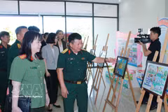 Des délégués visitent une exposition de photos présentant les activités de prévention des mines au Vietnam. Photo: VNA