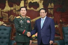 Le Premier ministre Pham Minh Chinh serre la main du général de division Saichay Kommasith, vice-ministre de la Défense et chef d’état-major général de l’Armée populaire lao, à Hanoi, le 5 mars. Photo: VNA