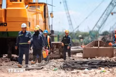 Un groupe d’ouvriers sur un chantier de construction profite d’une courte pause entre deux quarts de travail. Photo : VNA