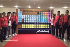 La délégation vietnamienne pose pour une photo à côté du tableau périodique des éléments de Mendeleïev avant la cérémonie d'ouverture. Photo : VNA