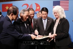 Le président Luong Cuong et les vétérans et les familles des vétérans vietnamiens et américains voient des souvenirs et des documents. Photo: VNA