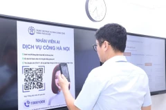Scanner des codes QR pour accomplir des démarches administratives au siège du Comité populaire du quartier de Cua Nam à Hanoi. Photo : VNA