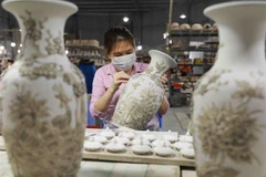 Décoration d'une vase dans le village de céramique de Bat Tràng, en banlieue de Hanoi. Photo : VNA