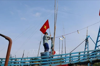 Les pêcheurs hissent le drapeau national pour affirmer la souveraineté des mers et des îles du pays. Photo: VNA