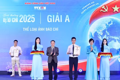 La directrice générale de la VNA, Vu Viet Trang (2e, droite), et le vice-président permanent de l'Association des journalistes du Vietnam, Nguyen Duc Loi (3e, gauche), remettent le prix A à un ouvrage des correspondants de la VNA. Photo : VNA