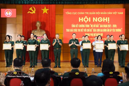 Le général Le Quang Minh, chef adjoint du Département général de la politique, et le général Pham Truong Son, chef d'état-major adjoint de l'Armée populaire du Vietnam, remettent des satisfecit à des collectifs et à des individus exemplaires. Photo : VNA