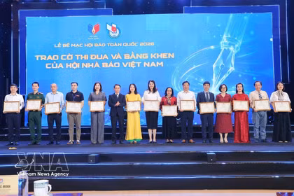 Remise des drapeaux d'émulation et des satisfecit de l'Association des journalistes vietnamiens. Photo: VNA