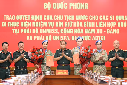 Le général de corps d’armée Phung Si Tan (au milieu) remet la décision à deux officiers de l’Armée populaire du Vietnam. Photo: VNA