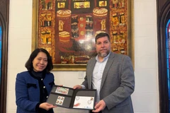 Le député Victor Aldaya remet à l'ambassadrice Ngô Minh Nguyêt une série de timbres commémorant le 20e anniversaire des relations diplomatiques entre le Vietnam et l'Uruguay, avec un portrait du général Vo Nguyên Giap. Photo: VNA