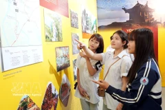 Des jeunes contemplent des oeuvres exposées lors de l'exposition thématique. Photo: VNA