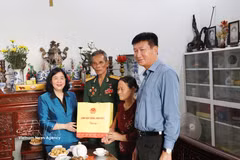 Mme Bui Thi Minh Hoai (premier, gauche), secrétaire du Comité central du Parti et présidente du Comité central du Front de la Patrie du Vietnam, offre un cadeau à la Mère vietnamienne héroïque Tran Thi Sach, née en 1920. Photo: VNA