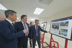 Le vice-ministre de l'Intérieur Cao Huy (gauche) et l'ambassadeur des Etats-Unis au Vietnam Marc Knapper contemplent des photos à l'exposition. Photo: VNA