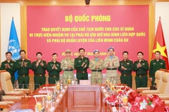 Cérémonie de remise des décisions du président de la République et du ministre de la Défense à deux officiers vietnamiens. Photo : VNA