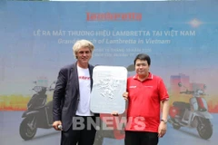 Un représentant de Lambretta remet le logo de l'entreprise à son distributeur officiel, la société Lamscooter Vietnam. Photo : VNA