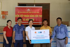 Des représentants du Fonds des Nations Unies pour l'enfance (UNICEF) remettent d'eau en bouteille aux ménages touchés par les inondations dans la commune de Huu Kiem, province de Nghê An. 