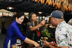 Un visiteur savoure le thé de Son La. Photo : VNA