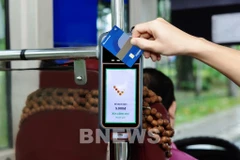 Les usagers pourront désormais utiliser leur carte ATM domestique NAPAS sans contact, émise par 28 banques, pour régler leurs trajets en la présentant simplement aux dispositifs installés dans les véhicules. Photo: VNA