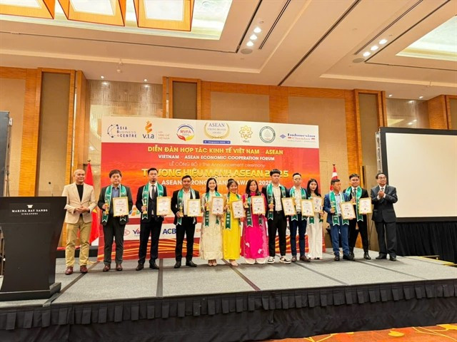 Phạm Thị Bích Hạnh (septième à partir de la droite, robe rose) reçoit le ASEAN Strong Brands Award avec d'autres lauréats. Photos gracieuseté du restaurant Quán Ăn Ngon.
