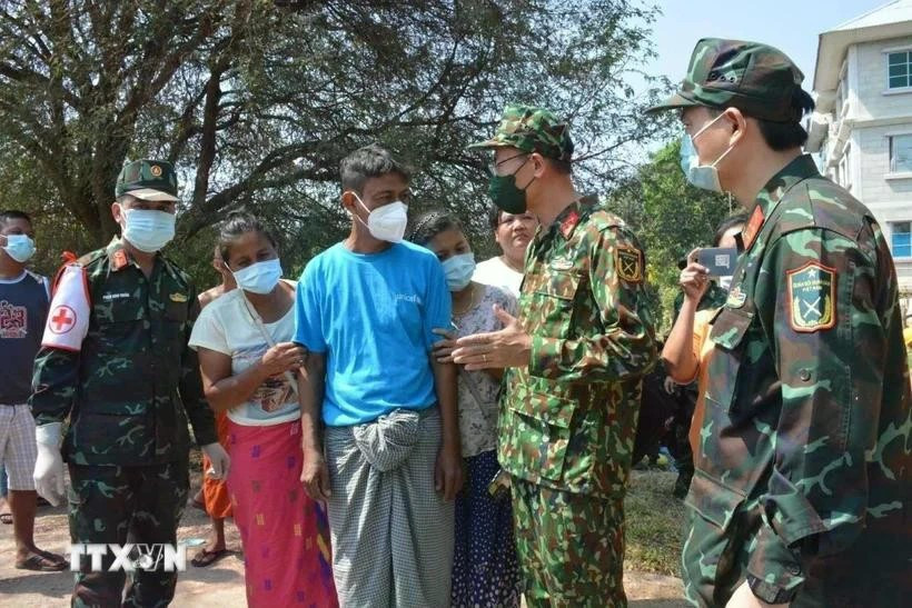 Des membres de l'Armée populaire vietnamienne discutent avec la population birmane des opérations de recherche et de sauvetage après le séisme. (Photo publiée par VNA)