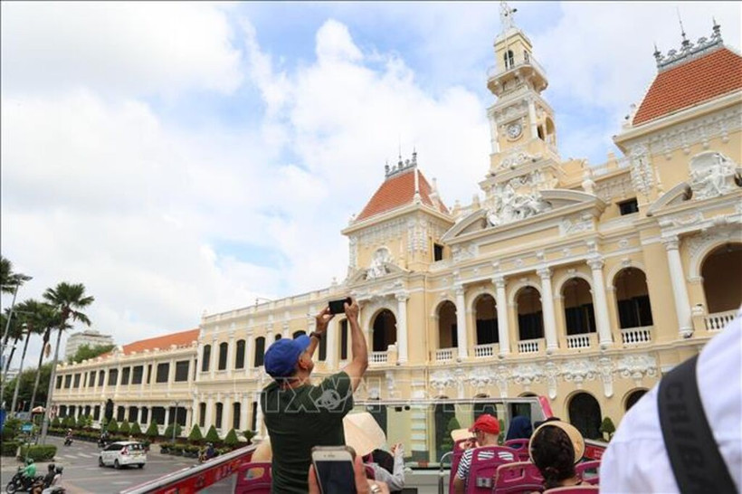 Des visiteurs internationaux explorent le centre-ville d'Hô Chi Minh-Ville à bord d'un bus à impériale. Photo : VNA