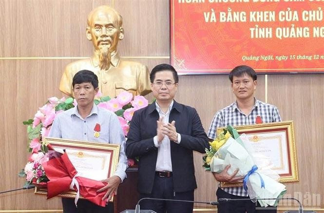Le président du Comité populaire de la province de Quang Ngai, Nguyên Hoàng Giang, remet la Médaille du Courage du Président de la République à deux citoyens de Ly Son. Photo : VNA