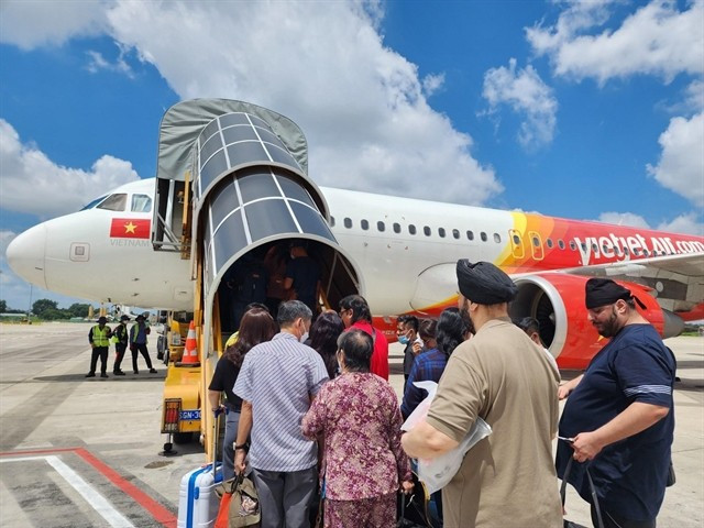 Des gens montent à bord d'un avion Vietjet. — Photo : Vietjet