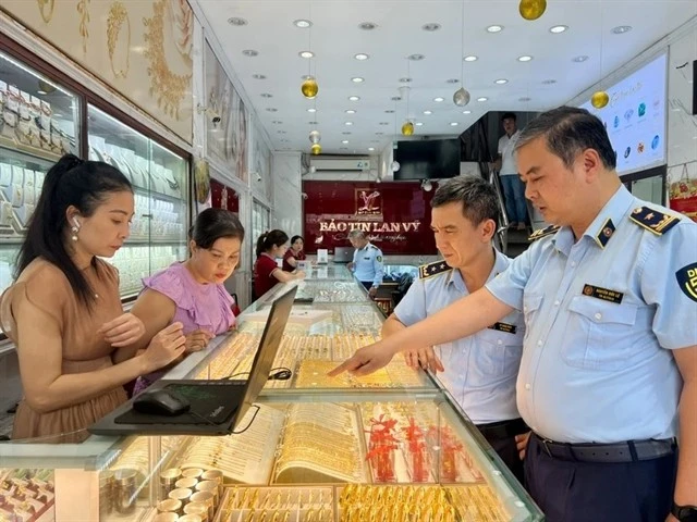 Inspecteurs du marché lors d'un contrôle de routine dans un magasin d'or de l'arrondissement de Cầu Giấy, Hà Nội. Photo / VNA
