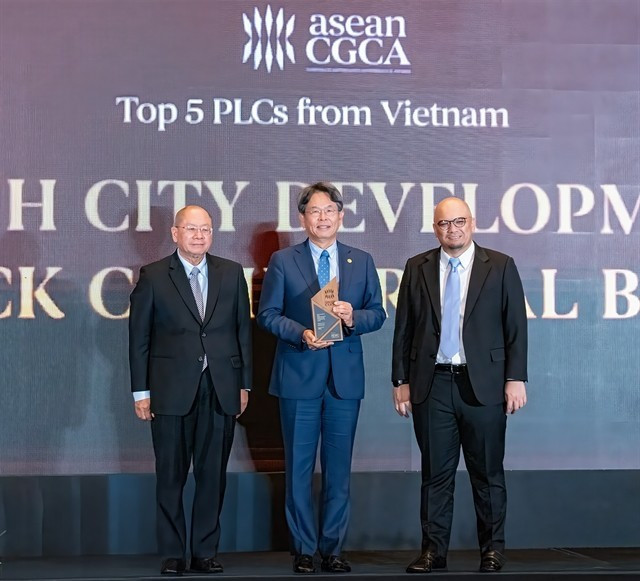 Le président de HDBank, Kim Byoungho (au centre), reçoit le prix des mains des organisateurs. — Photo : VNA