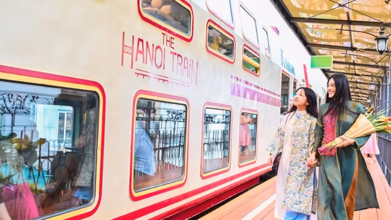Des touristes testent le train à cinq portes, une nouvelle attraction touristique d'Hanoï. Photo : nhandan.vn