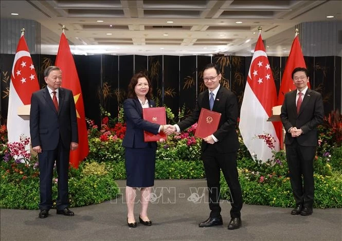 Le secrétaire général To Lam et le Premier ministre singapourien Lawrence Wong assistent à la cérémonie de lettre d'intention entre la Commission nationale des valeurs mobilières du Vietnam (SSC) et l'Autorité monétaire de Singapour (MAS). Photo : VNA