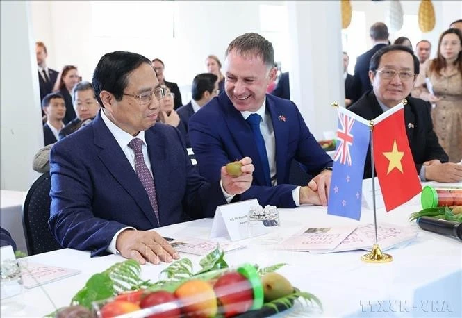 Le Premier ministre Pham Minh Chinh avec des produits de l'Institut néo-zélandais de recherche sur les plantes et les aliments. Photo : VNA