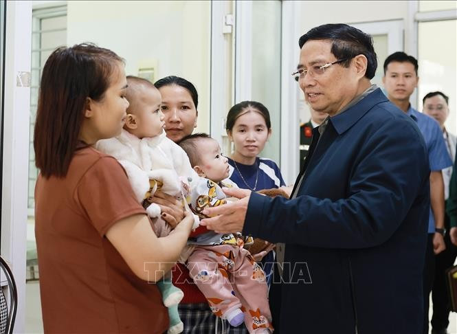 Le Premier ministre Pham Minh Chinh et des habitants se rendent au centre de santé communal de Yen Khuong pour un examen et des soins médicaux. Photo : VNA