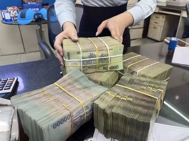 Un employé de banque compte l'argent d'un client dans une agence privée à Ho Chi Minh-Ville. (Photo : VNA)