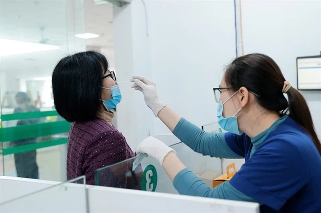 Un travailleur médical prélève un échantillon pour un test de dépistage de la grippe. — VNA/VNS