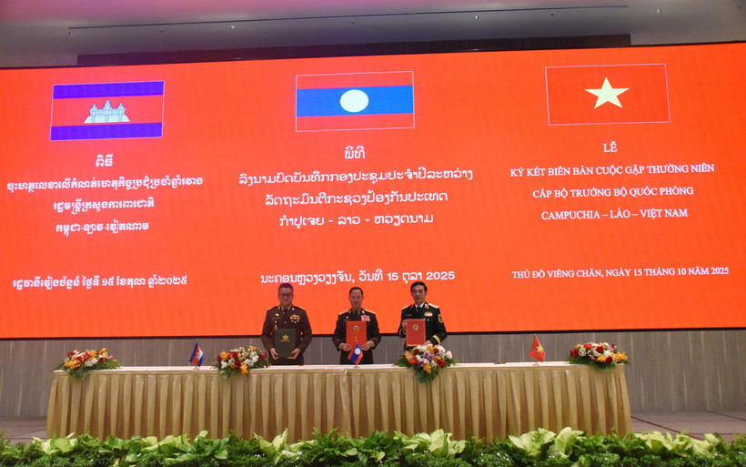 Les ministres de la Défense du Vietnam, du Laos et du Cambodge signent le compte rendu de leur réunion annuelle à Vientiane, le 15 octobre. (Photo : VNA)