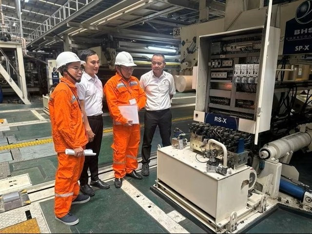 Des ingénieurs d'EVN inspectent des équipements électriques dans une usine de Hanoï. Photo VNA