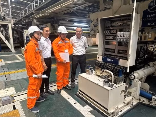 Des ingénieurs d'EVN inspectent des équipements électriques dans une usine de Hanoï. Photo VNA