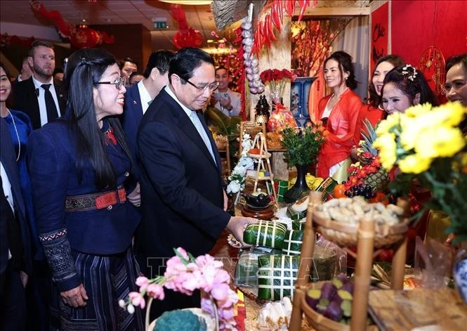 Le Premier ministre Pham Minh Chinh et son épouse visitent un stand du Têt de la communauté vietnamienne lors de l'événement (Photo : VNA)