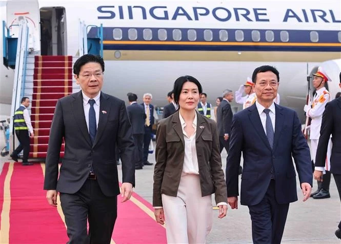 Le Premier ministre Lawrence Wong et sa suite ont été accueillis à l'aéroport international de Noi Bai par le ministre des Sciences et des Technologies, Nguyen Manh Hung. Photo . VNA