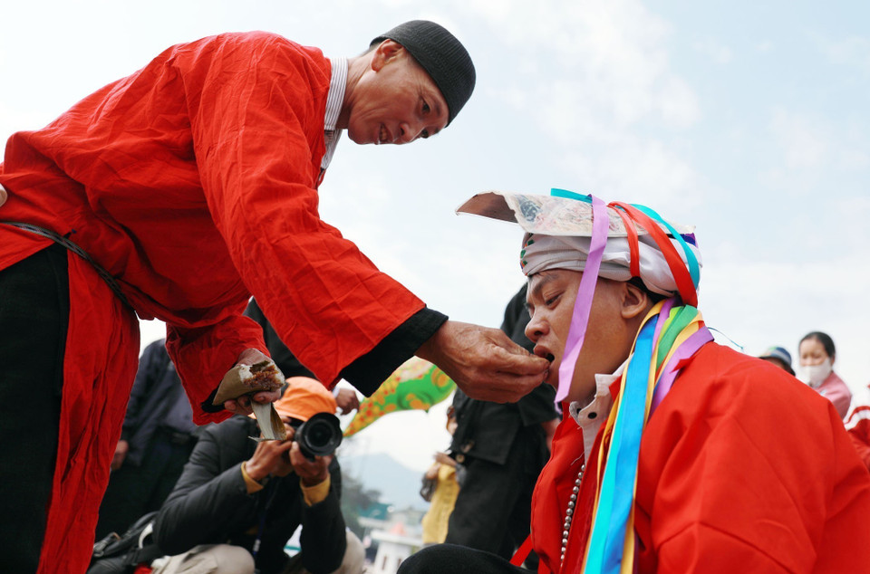 Le sorcier donne du riz à la personne qui passe le rituel « tu cai », à ce moment-là, il est considéré officiellement comme mature. Photo: VNA
